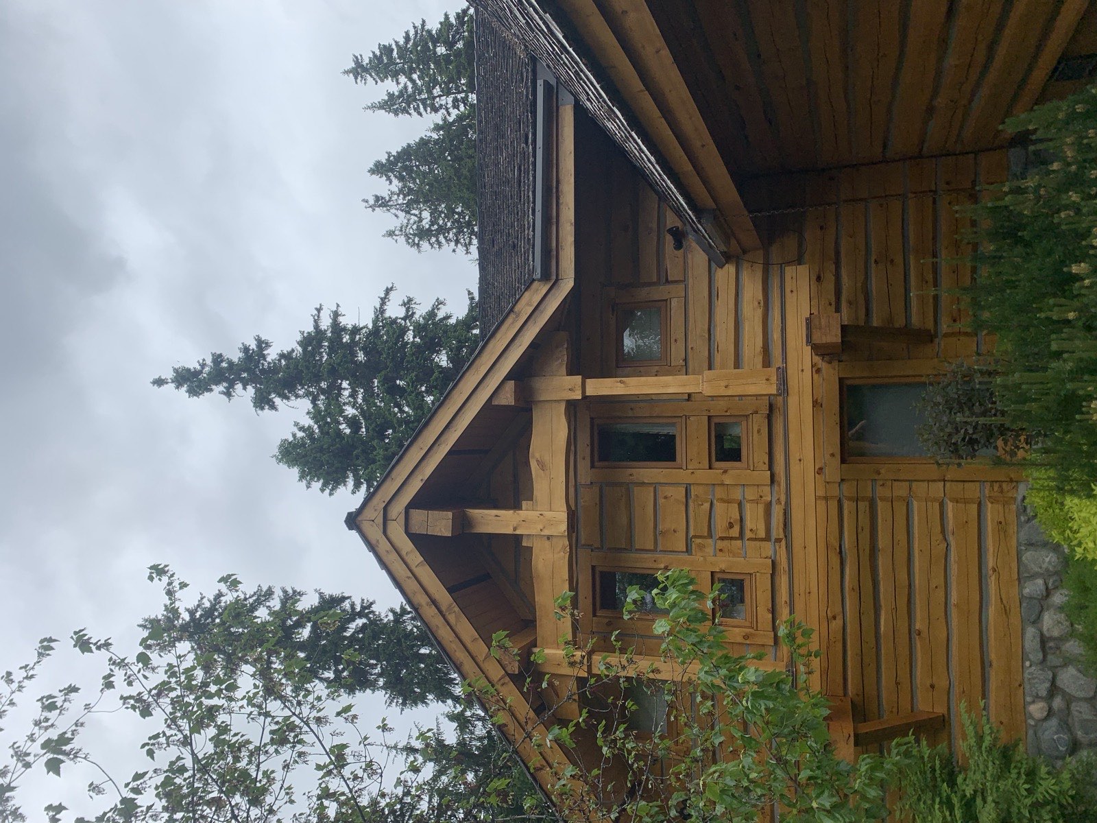 Log home staining Pemberton BC - refinished log home under cloud