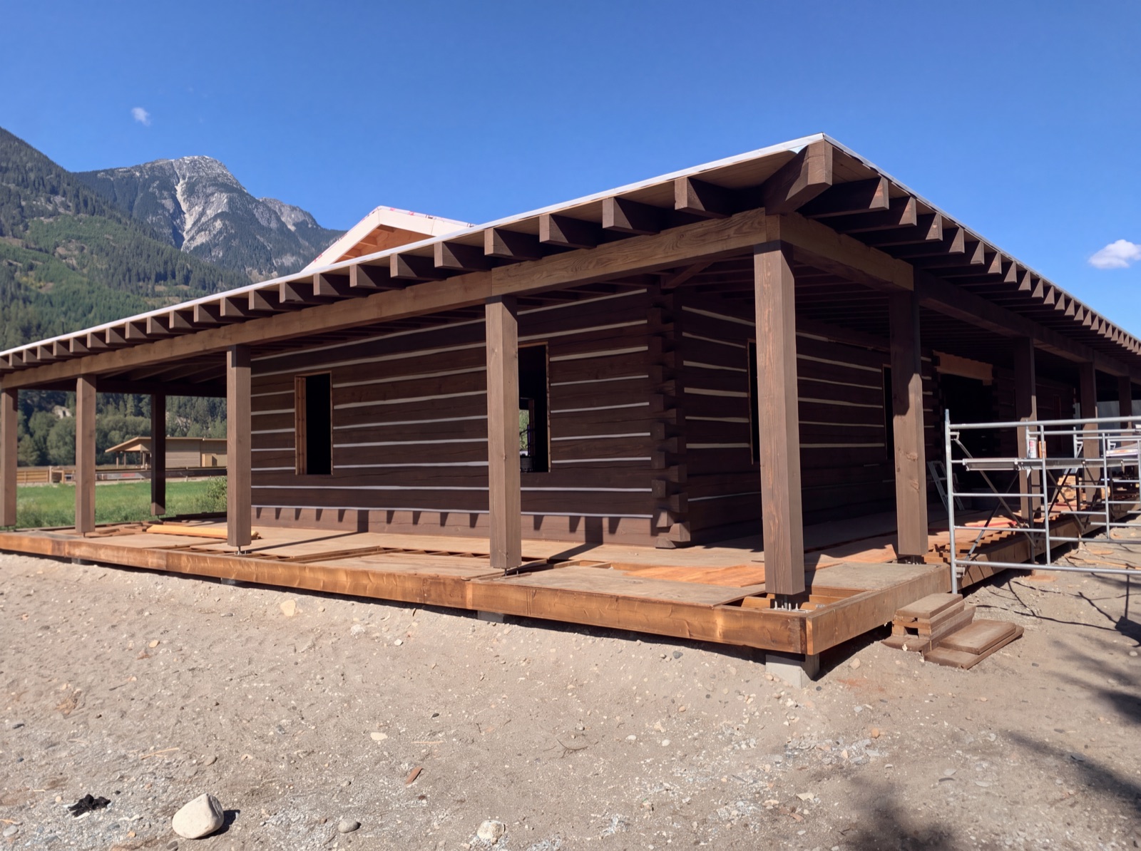 Log home chinking Pemberton Meadows BC - dovetail log home with wraparound porch under the mountains