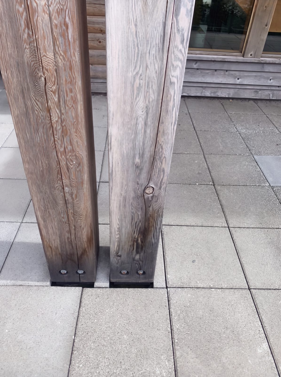 Weathered grey timber posts before log home sanding and staining, Whistler BC
